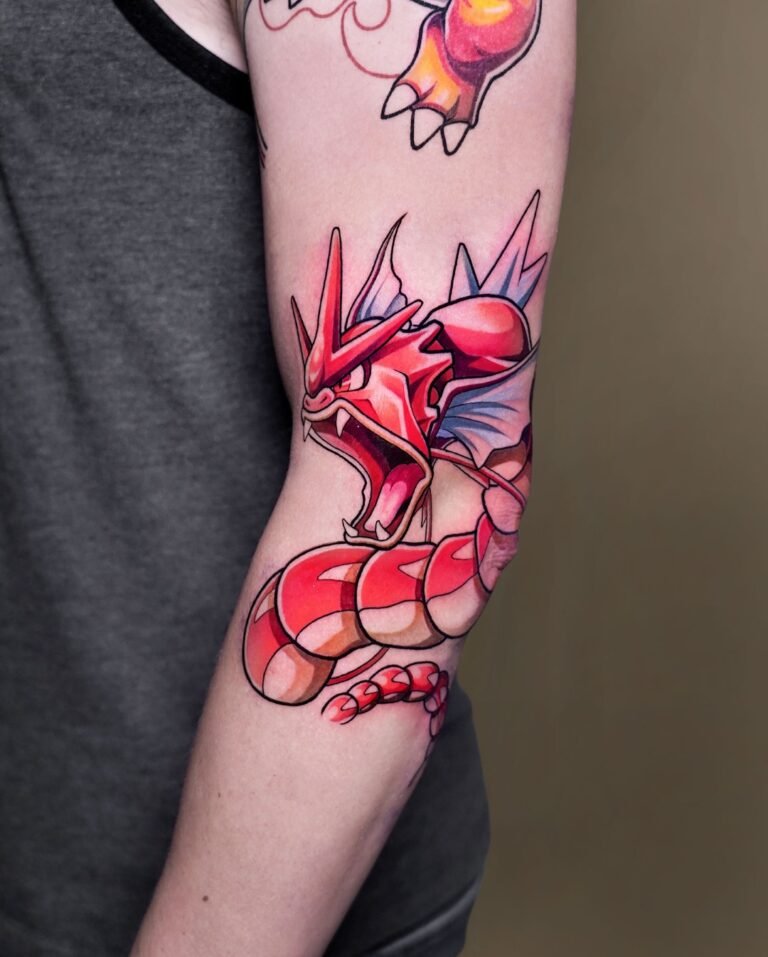 Anime color sleeve tattoo of a shiny red Gyarados from Pokémon coiling around the elbow