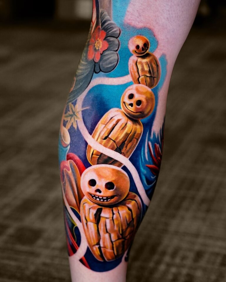 Color fantasy leg tattoo of smiling skull-faced spirit figures with flowers on the calf